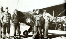 Le capitaine Jean Callet (3ème en partant de la gauche) et le lieutenant Etienne Mantoux posent devant le Piper J-4 « Grasshoppers »